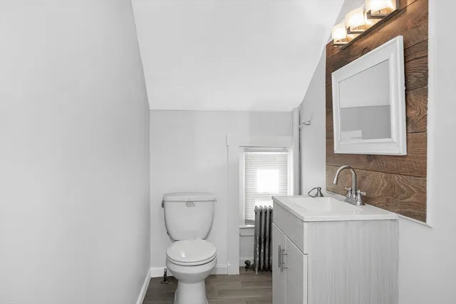 a bathroom with a toilet sink and mirror