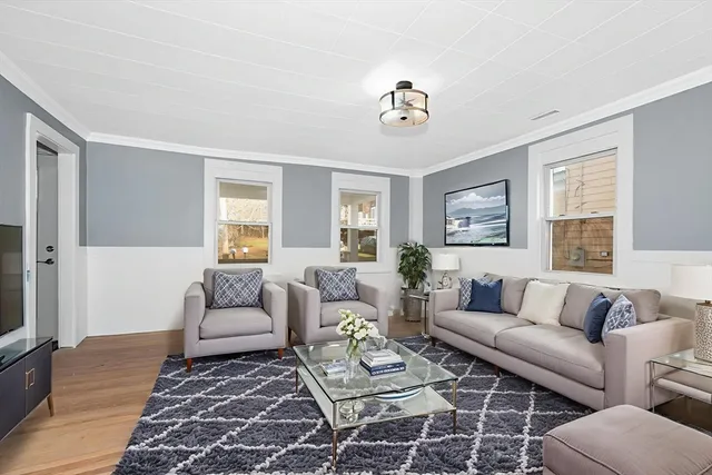 a living room with furniture a rug and a window