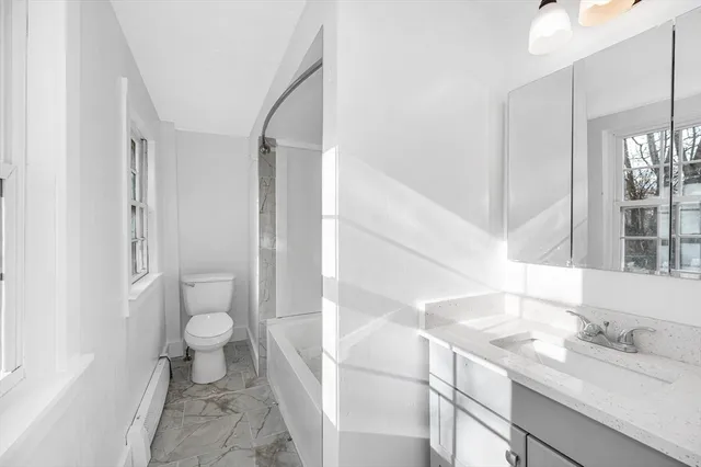 a bathroom with a sink toilet a mirror and a shower