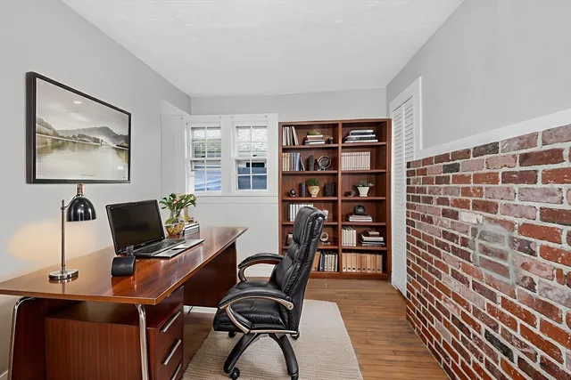 a view of a workspace with furniture and a window