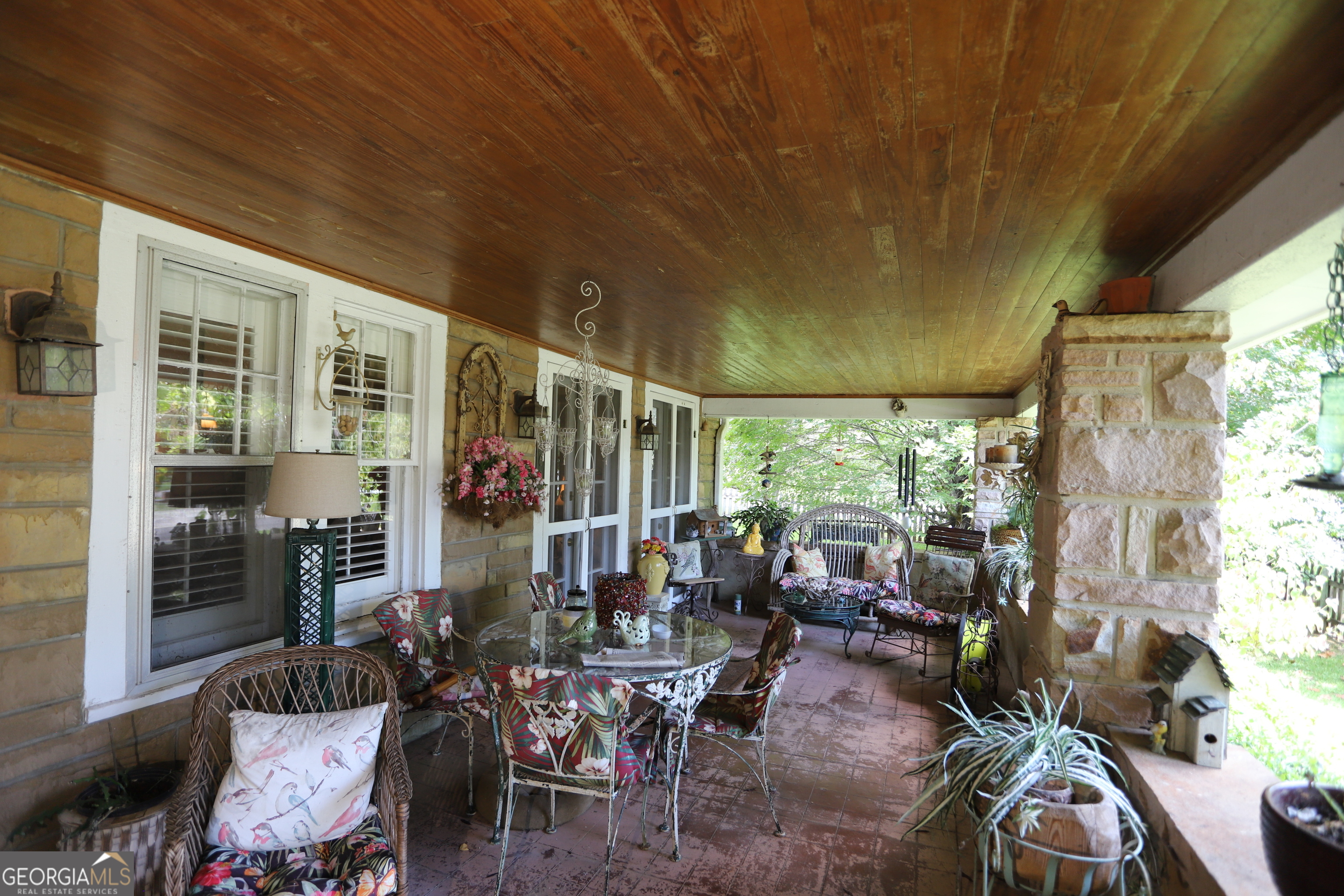 360 Edison Street Menlo, GA 30731 - Photo 14 of 64 a view of a patio with table and chairs potted plants and floor to ceiling window