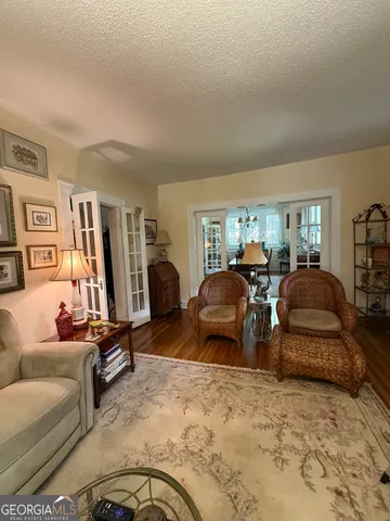 a room with stainless steel appliances kitchen island granite countertop furniture a rug and a window