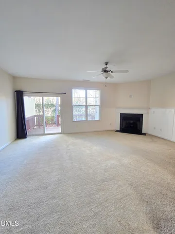 an empty room with windows and ceiling fan