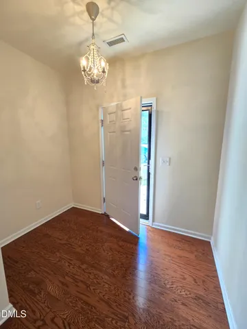 a view of a chandelier in big room with wooden floor