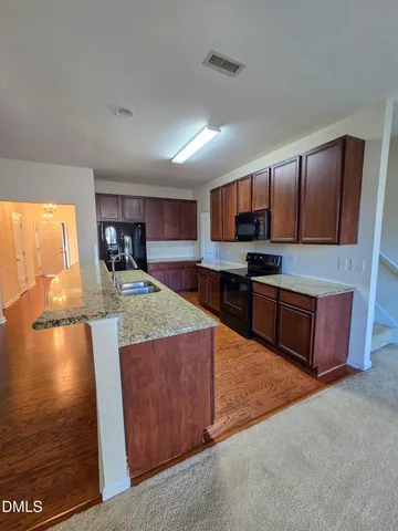 a kitchen with stainless steel appliances granite countertop a stove a sink and a microwave