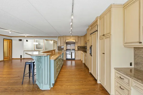 a kitchen with kitchen island granite countertop lots of wooden cabinets a sink appliances and a center island
