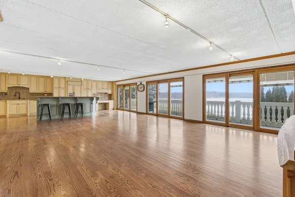 a view of a big room with wooden floor and windows