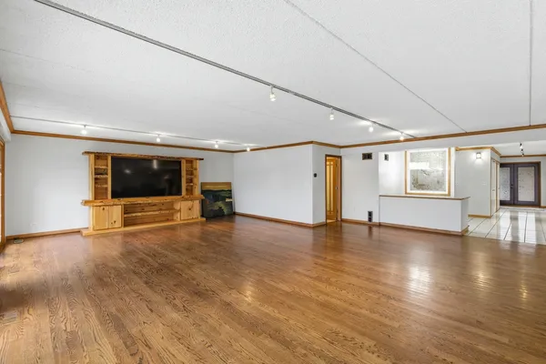 a view of empty room with wooden floor