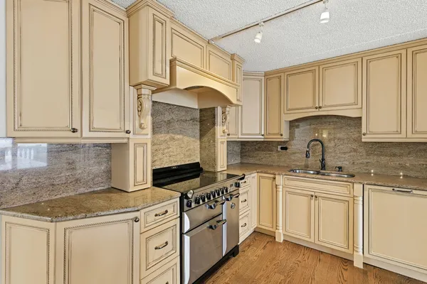 a kitchen with granite countertop white cabinets and white appliances