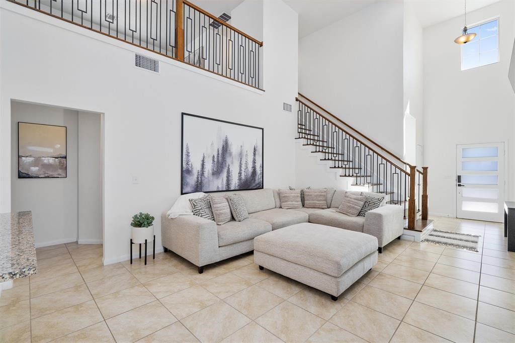 10308 Hatton Lane Austin, TX 78754 - Photo 4 of 25 Light-filled living room with soaring ceilings, modern iron staircase, and an open layout that creates an immediate sense of space and flow