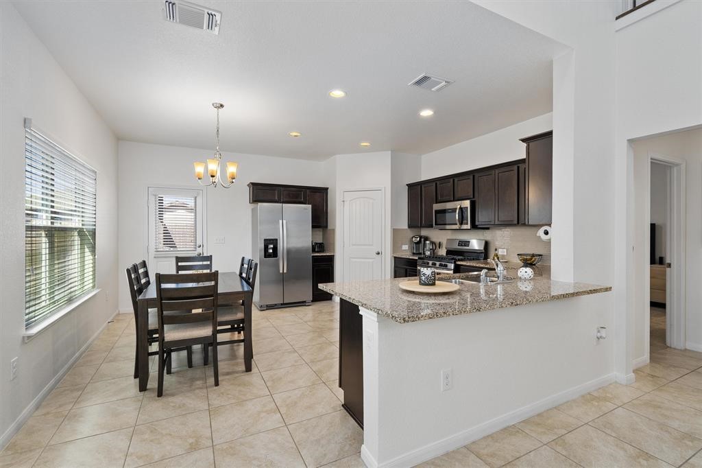 10308 Hatton Lane Austin, TX 78754 - Photo 7 of 25 Spacious kitchen and dining area with granite countertops, stainless steel appliances, and an open design ideal for everyday living and entertaining