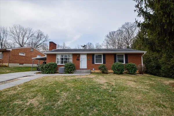 a front view of a house with a yard and potted plants