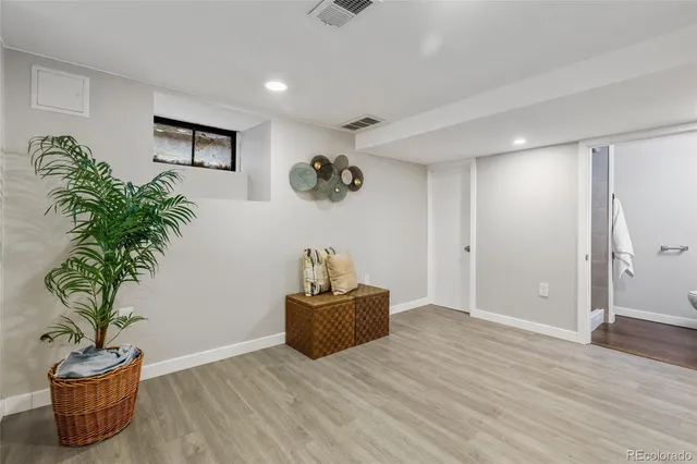 a view of a room with wooden floor and potted plant