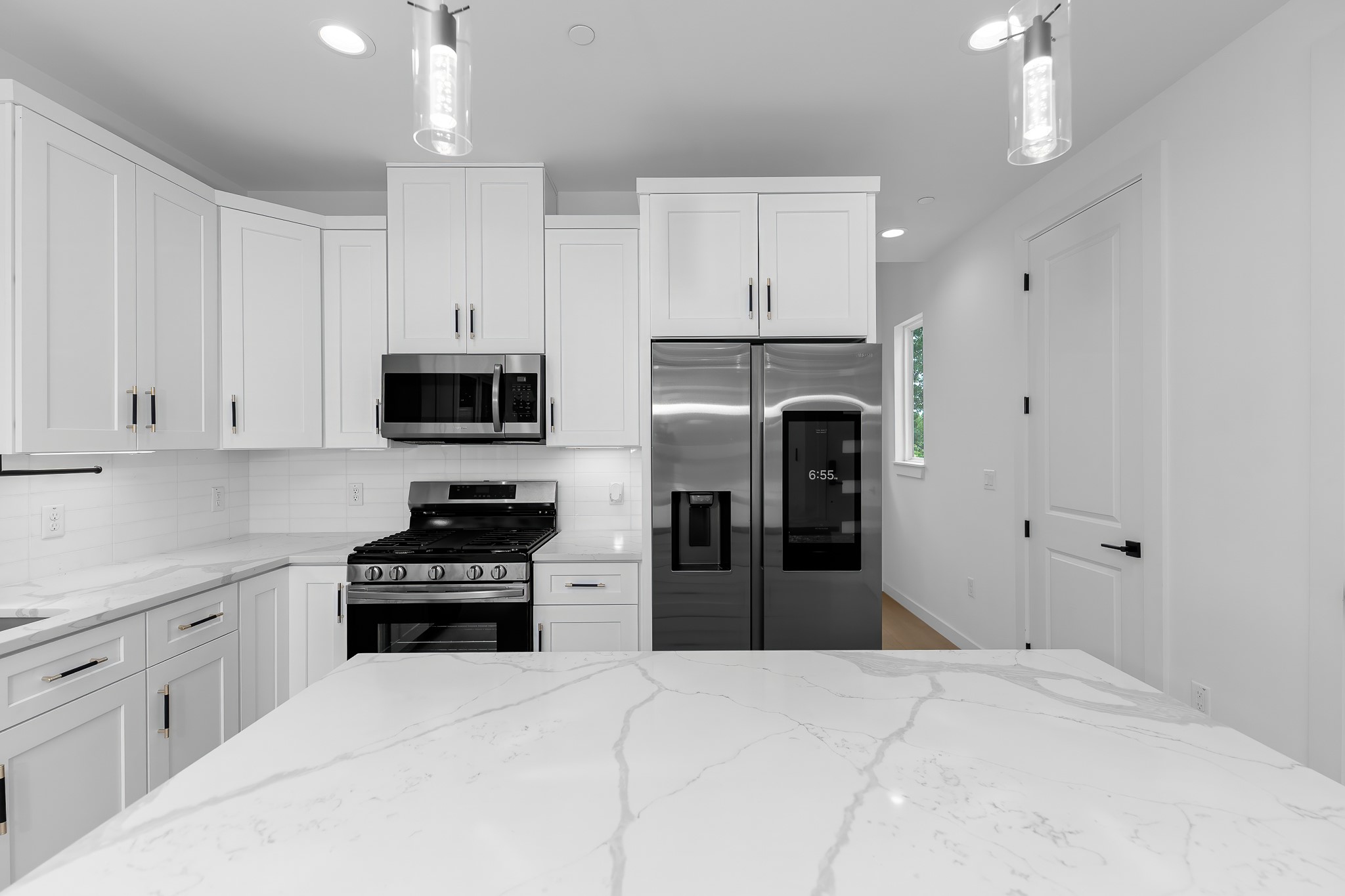 5305 Ledesma Road, Unit 4 Austin, TX 78721 - Photo 14 of 40 Modern kitchen with sleek white cabinetry, gleaming countertops, and integrated stainless steel appliances.