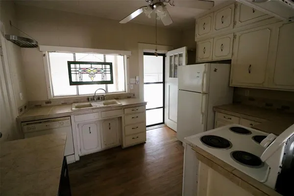 a kitchen with refrigerator cabinets and wooden floor