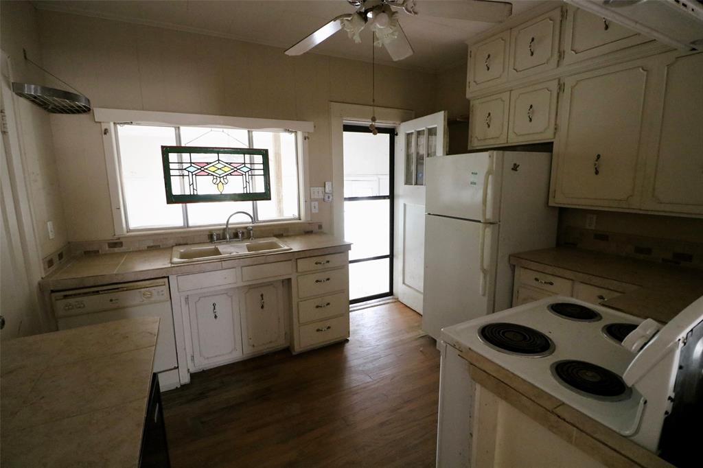 2332 Simpson Street Paris, TX 75460 - Photo 14 of 16 a kitchen with refrigerator cabinets and wooden floor