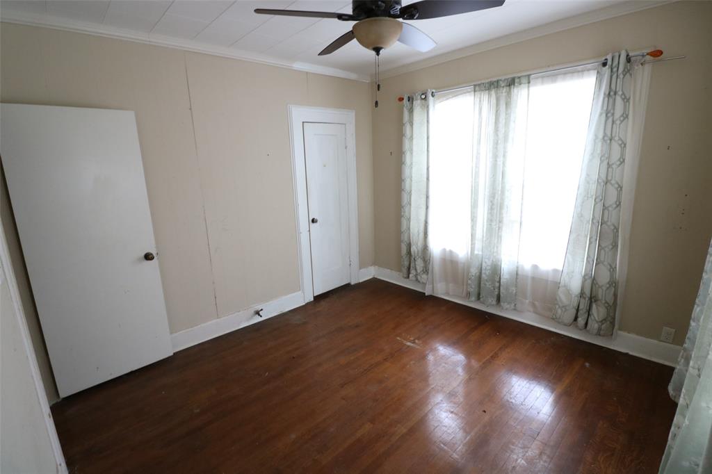 2332 Simpson Street Paris, TX 75460 - Photo 2 of 16 a view of an empty room with wooden floor and a window