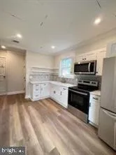 a kitchen with stainless steel appliances kitchen island granite countertop a refrigerator stove and sink