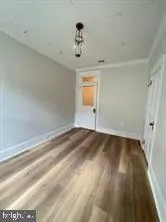 a view of a room with wooden floor and a ceiling fan
