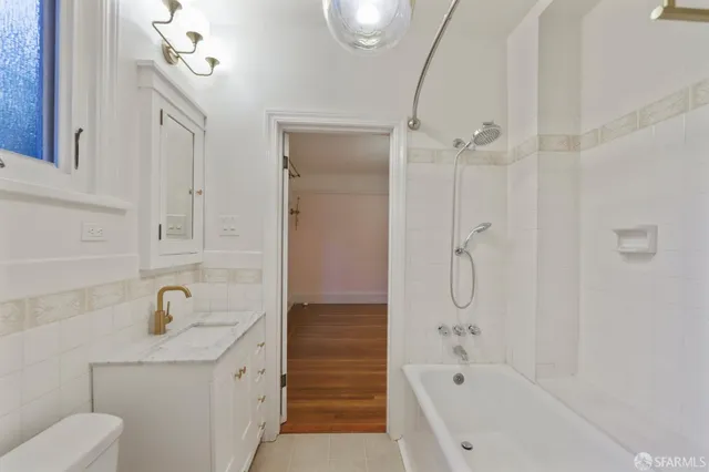 a bathroom with a bathtub shower sink mirror and toilet