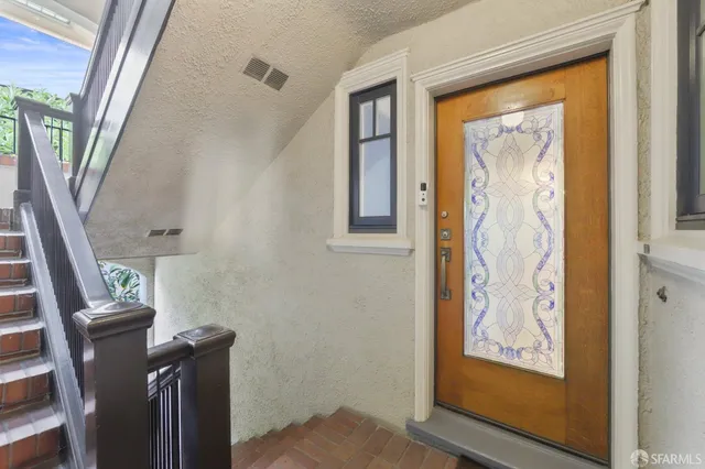 a view of a hallway with wooden door and glass door