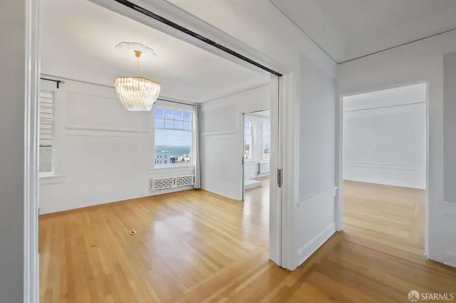 a view of an empty room with wooden floor