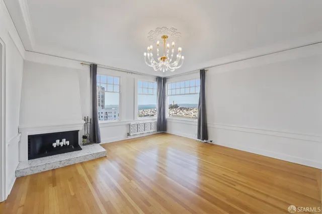 a view of an empty room with a fireplace and a window