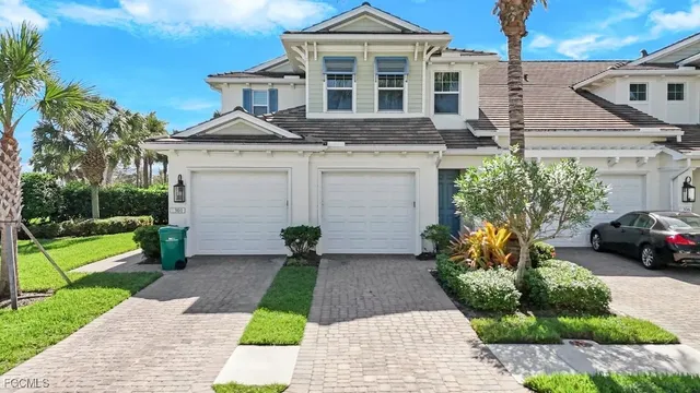 a front view of a house with a yard and potted plants