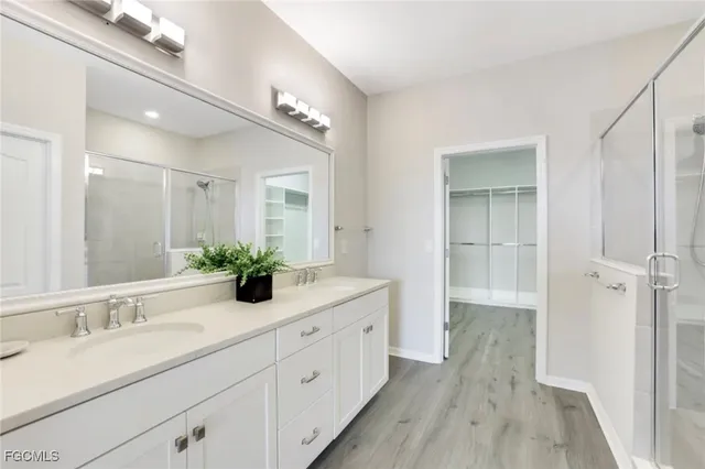 a spacious bathroom with a double vanity sink a mirror a vanity and shower