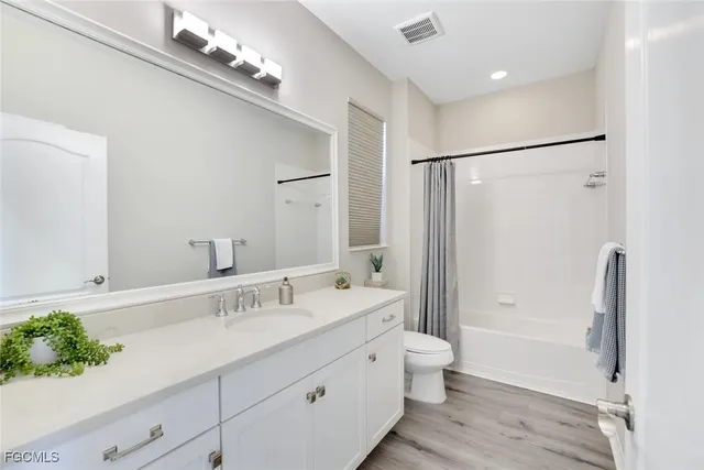 a bathroom with a double vanity sink toilet and shower
