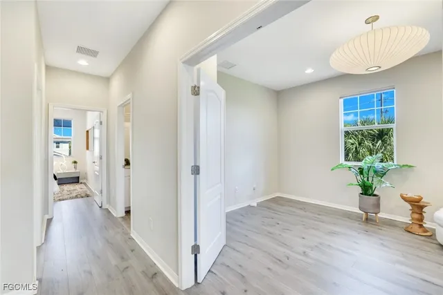 a view of a hallway with wooden floor and a potted plant