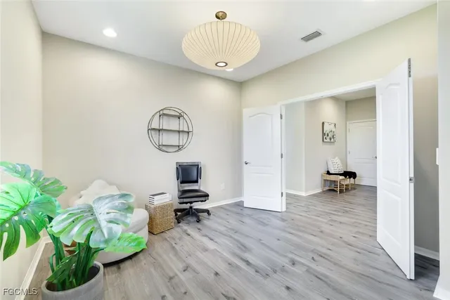 a view of a hallway with wooden floor and a potted plant