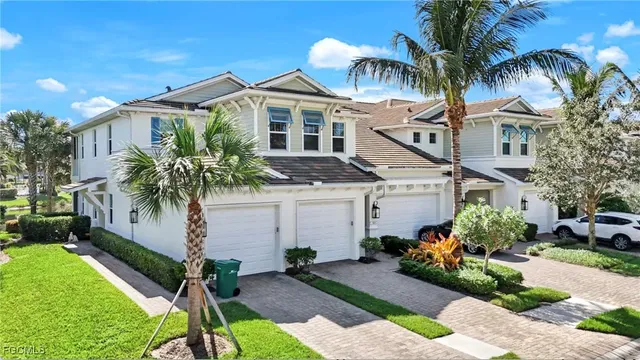 a front view of a house with a yard and potted plants