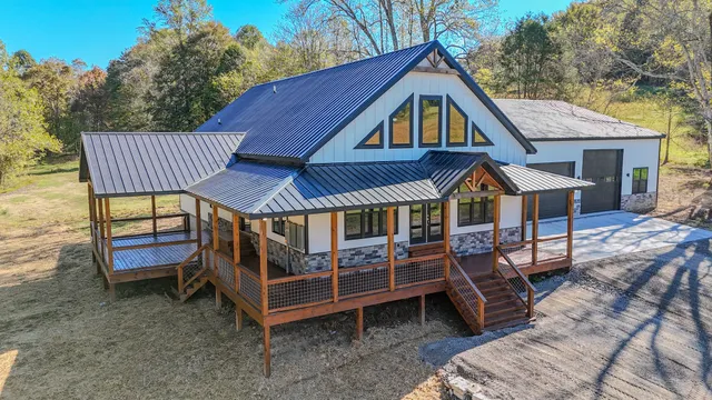 a view of a house with a yard and a wooden deck