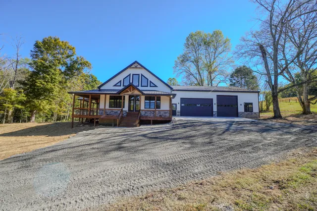 a front view of a house with a tree
