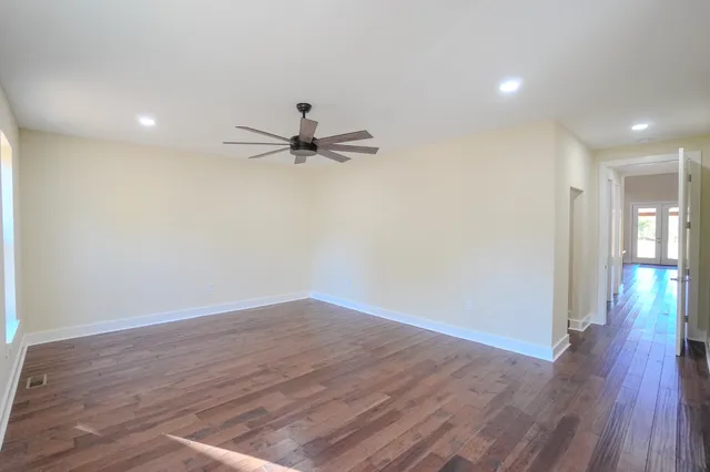 a view of a room with wooden floor and a ceiling fan