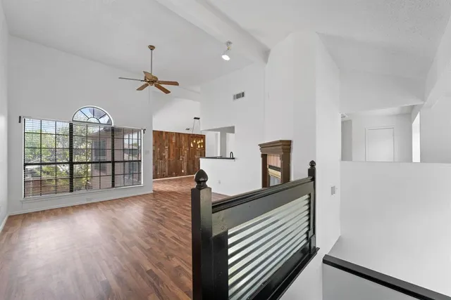 a view of a room with wooden floor and ceiling fan