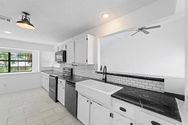 a kitchen with a sink appliances and cabinets