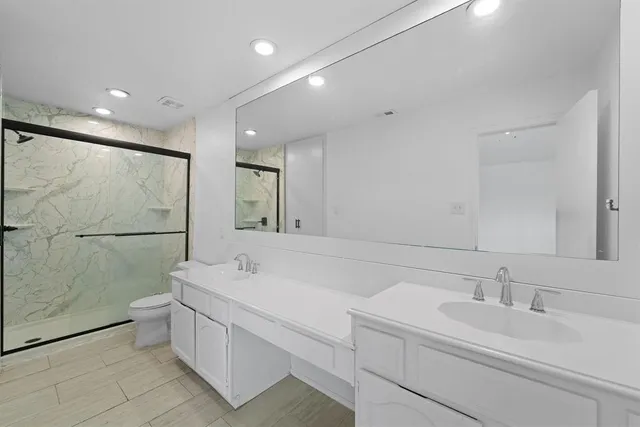 a bathroom with a double vanity sink mirror and shower