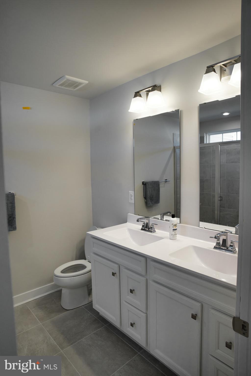 549 Lewes Landing Road Middletown, DE 19709 - Photo 15 of 19 a bathroom with a double vanity sink toilet and mirror