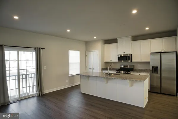 a kitchen with stainless steel appliances a refrigerator sink and microwave