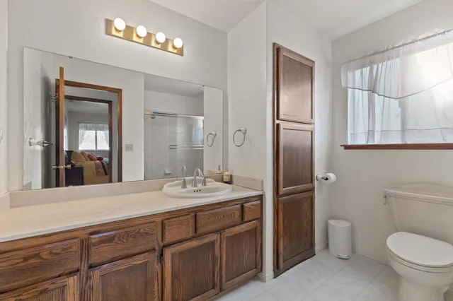 a spacious bathroom with a toilet sink and mirror