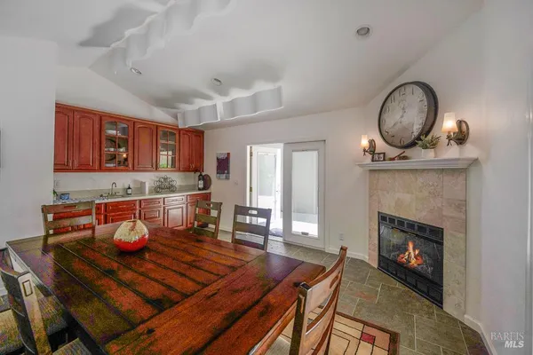 a living room with furniture a fireplace and kitchen view