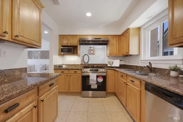 a kitchen with stainless steel appliances granite countertop a stove sink and cabinets
