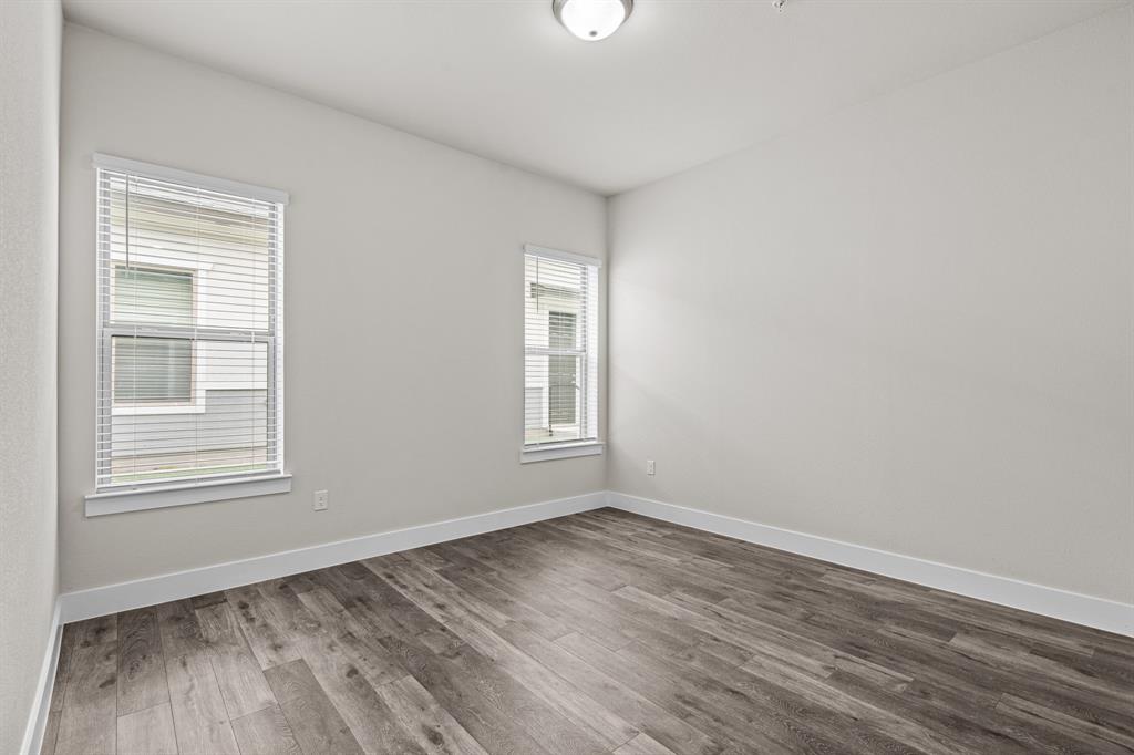 3283 Ganzer Road West, Unit 1105B Denton, TX 76207 - Photo 12 of 37 a view of an empty room with wooden floor and a window