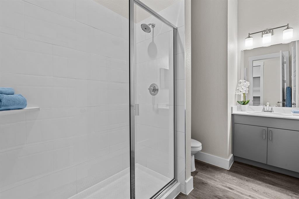 3283 Ganzer Road West, Unit 1105B Denton, TX 76207 - Photo 17 of 37 a bathroom with a granite countertop sink toilet and shower