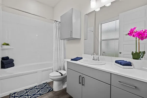 a bathroom with a granite countertop sink a toilet and shower