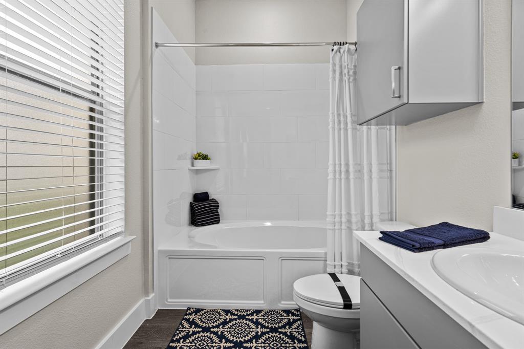 3283 Ganzer Road West, Unit 1105B Denton, TX 76207 - Photo 24 of 37 a bathroom with a shower a toilet and a sink