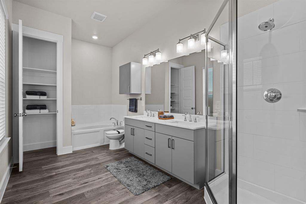 3283 Ganzer Road West, Unit 1105B Denton, TX 76207 - Photo 31 of 37 a bathroom with a double vanity sink toilet mirror and bathtub