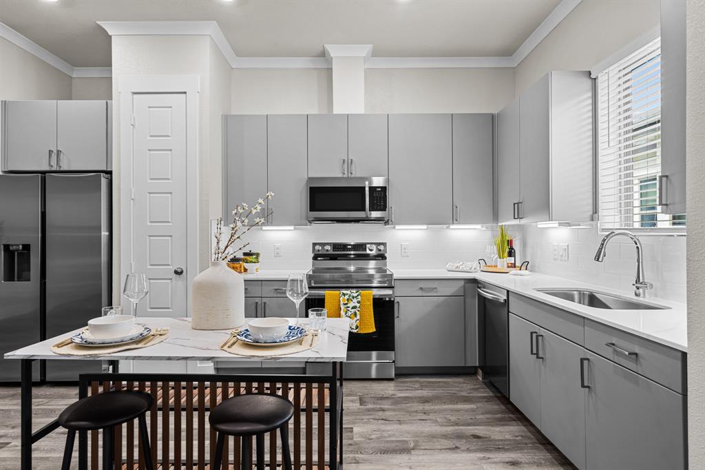 3283 Ganzer Road West, Unit 1105B Denton, TX 76207 - Photo 8 of 37 a kitchen with a stove a sink and a refrigerator